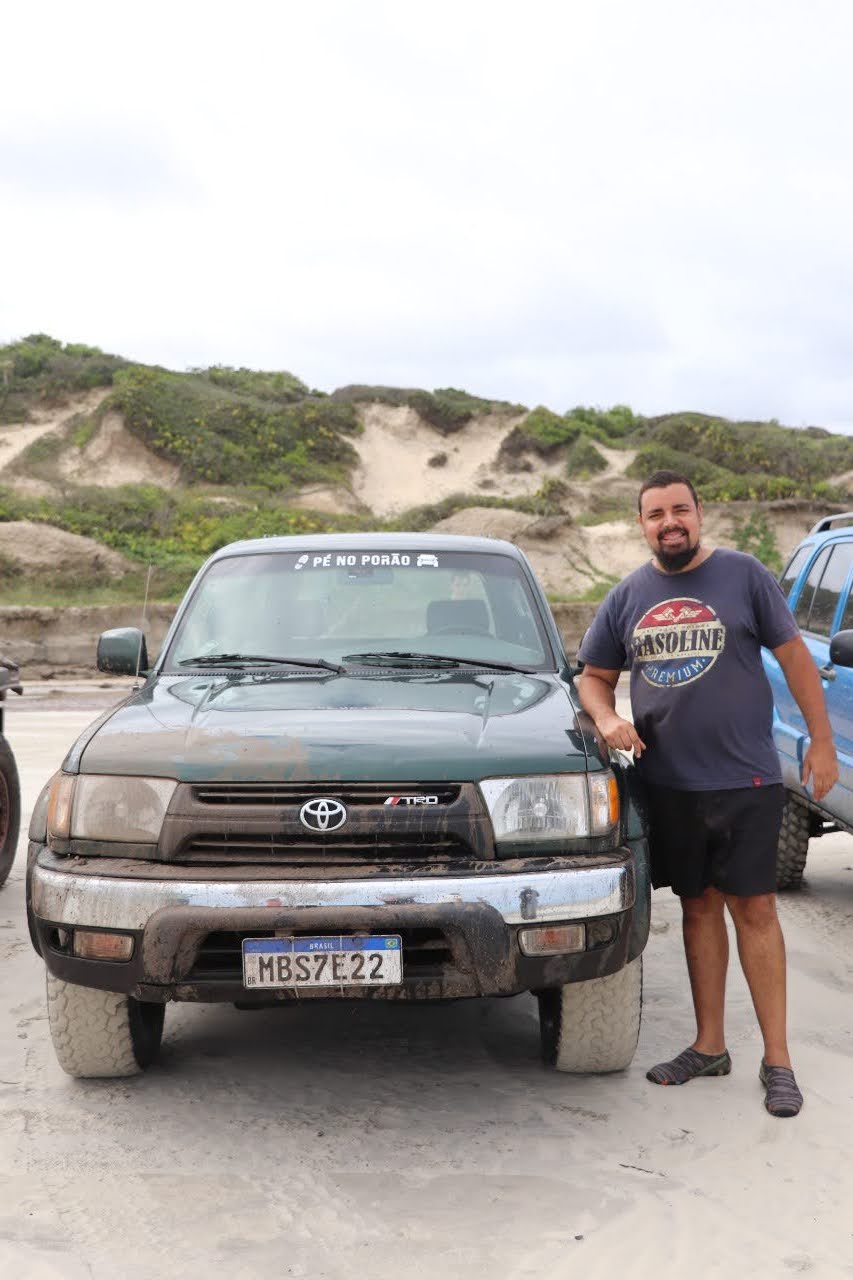 Toyota Hilux SW4 Hulk na praia, com o proprietário ao lado