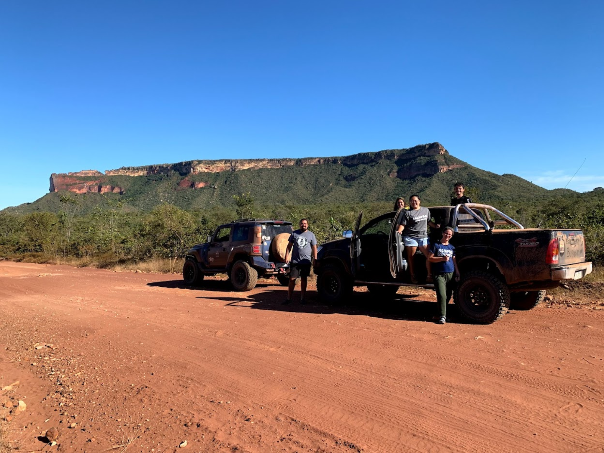 Grupo ao lado do Troller TX4 em estrada de terra com paisagem do Jalapão ao fundo