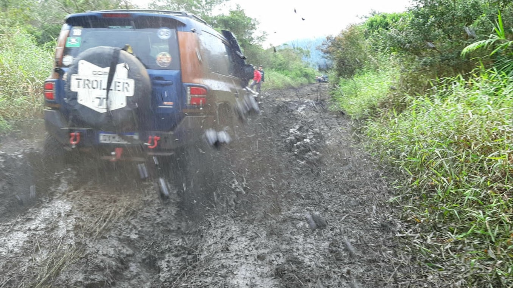 Troller TX4 avançando em lama vista traseira