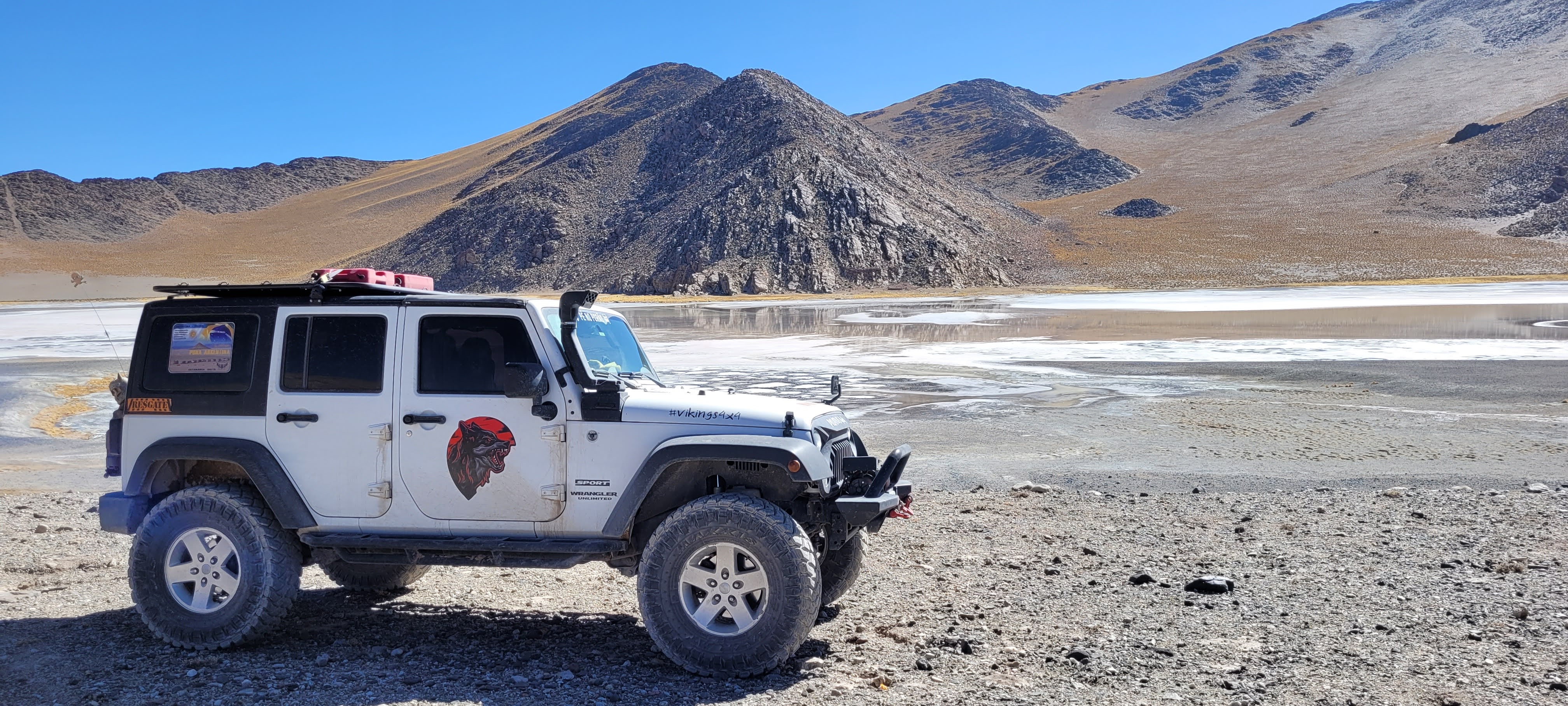 Jeep Wrangler em cenário de montanha e lago