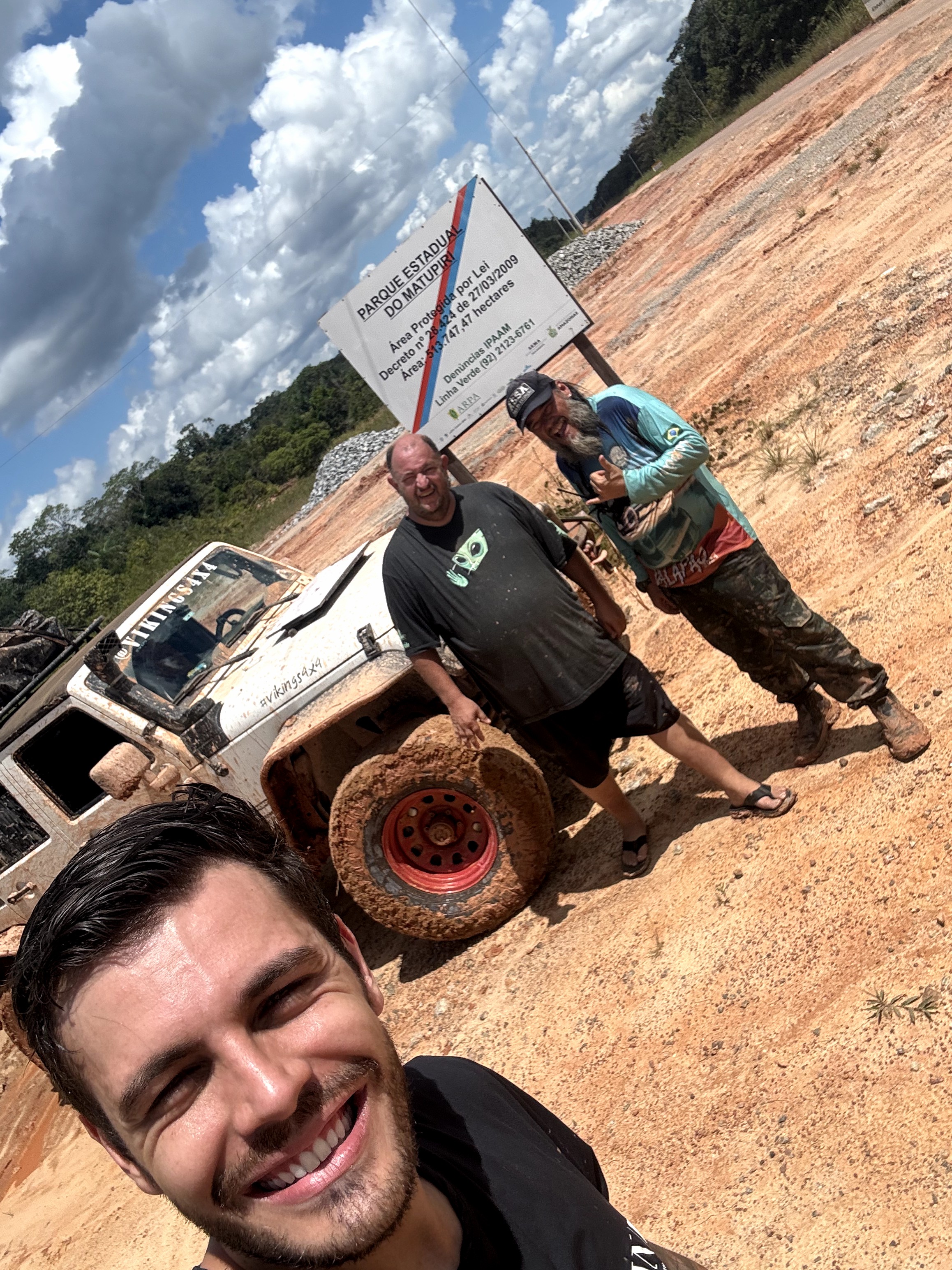 Jeep Wrangler com pessoas ao lado em trilha